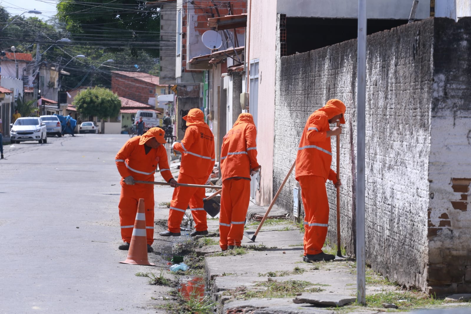 homens varrendo uma via